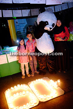 Children take the chance to pose with the panda mascot of the World Wildlife Fund at the event. — Photos by Russel Ting