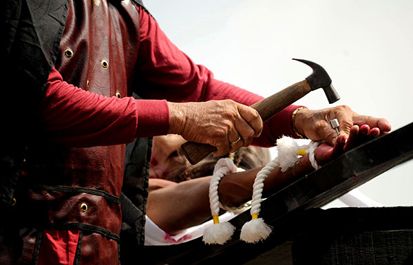 Willy Salvador, 59, is nailed to a cross as part of his penitence during a reenactment of the crucifixion of Jesus Christ for Good Friday  ahead of Easter in the village of San Juan, Pampanga, north of Manila. — AFP photo