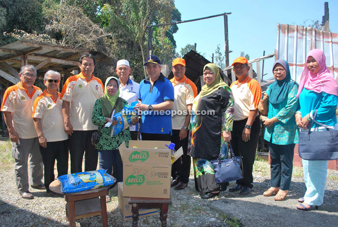 Awang Tengah hands over the donation and daily essentials to the family of the fire victims of Kampung Pahlawan on Sunday.