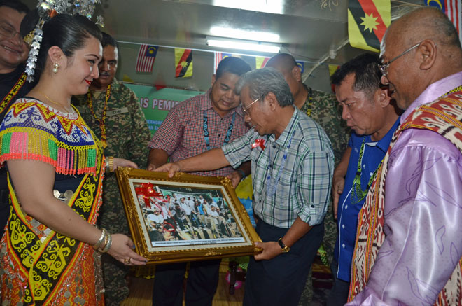 Masing (third right) admires the photo of him presented as a memento by Magai (right) as (from second right) Alexander, Stephen (partly hidden), Aaron and Zaki look on.
