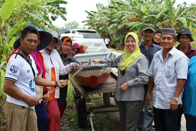 Simoi (right) presenting the boats to the villagers.