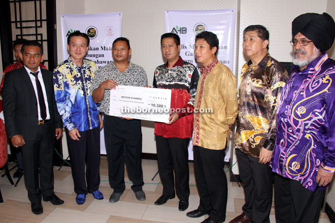 AHB’s corporate advisor Tengku Baharuddin presents the mock cheque to Watson (third from left). — Photo by Chimon Upon