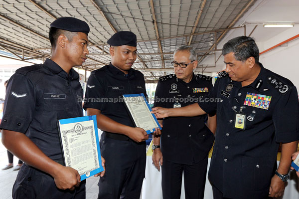 Khalid (right) talking to police personnel who received certificates at the Johor police contingent headquarters. — Bernama photo 