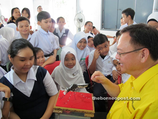 Lo shows a mock Aedes mosquito to pupils.