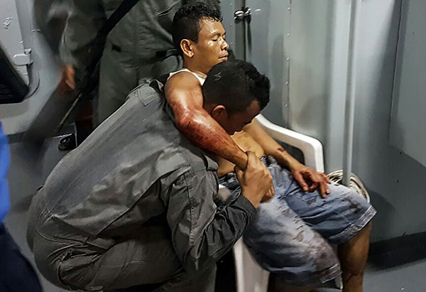 A member of the Malaysian Maritime Enforcement Force rescuing an Indonesian sailor who was shot during the kidnapping. — AFP photo
