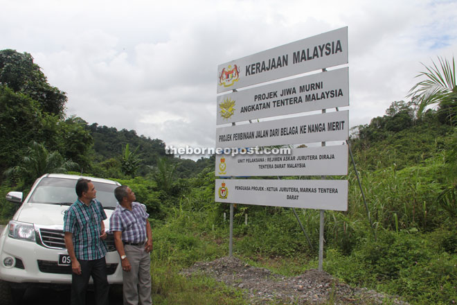 Councillor Bete Lahang (left) and Pemanca Ajang Sirek look at the signboard for the proposed Belaga-Nanga Merit Road, which will be implemented under the Jiwa Murni programme.