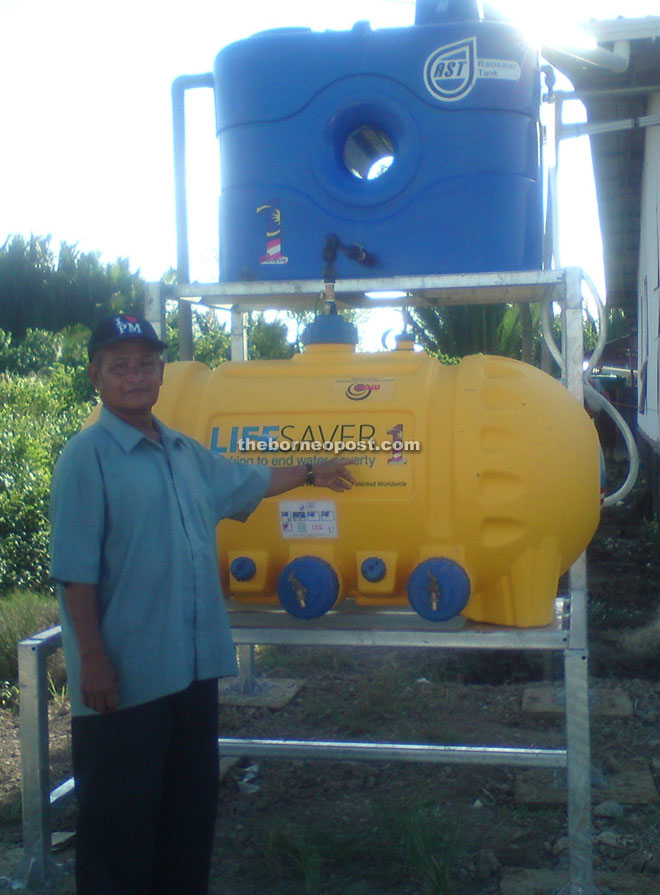 A villager shows the water filtration system installed for the benefit of residents of two longhouses in Kabong.