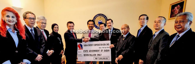 Harun (fifth left) presenting the RM7 million dividend to Pengiran Hassanel, witnessed by Musa and Au.