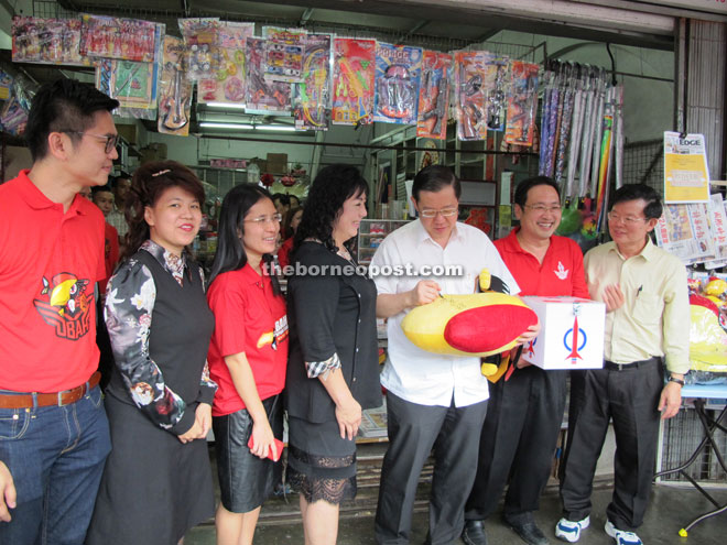 Lim (second right) signs on a big ‘Ubah’ for donor Teresa Ng Lee Yong (third right). Also seen from left are DAP’s candidate for Padungan Wong King Wei, Yong, Chiew and Chong.