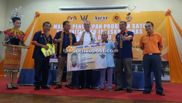Wan Junaidi (centre) alongside Ibrahim (second left), Abdul Aziz (third left) and others giving the thumbs-up when presenting an elderly participant with his motorcycle probationary driving licence (P).