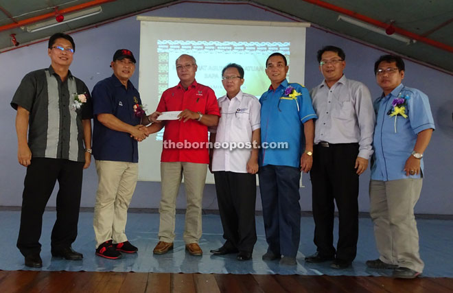 Ugak (second left) presents RM6,000 to PTA chairman Tuai Rumah Gendang Sugit. 