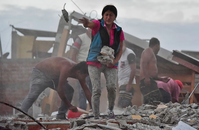 Ecuadorean Veronica Paladines removes rubble in search for her husband at Tarqui neigbourhood in Manta, Ecuador a day after a powerful quake hit the country. — AFP photo