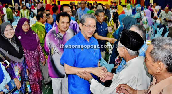 Fadillah and Dr Annuar (at right, behind Fadillah) exchanging greetings with the people. 
