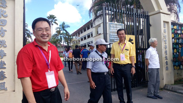 POLLING DAY HELLO: BN-SUPP Wilfred Yap (second right) and DAP Chong Chieng Jen (left) greeting voters for Kota Sentosa constituency at SRB Sam Hap Hin yesterday.