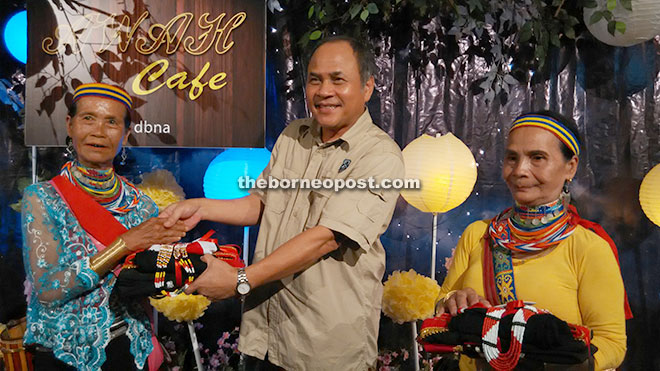 Boniface (centre) presents traditional costumes to Tawud (left) and Singai.