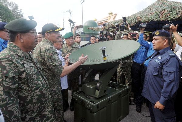 Hishammuddin (second left) and his deputy  Datuk Seri Mohd Johari Baharum (left) witnessing the Network Centric Operations (NCO) and the Armed Forces X-Band Satellite demonstrations at the Royal Malaysian Air Force Base. — Bernama photo