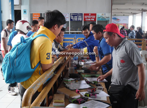 Passengers buying their tickets to go home for Gawai Dayak at Sibu Express Boat Terminal.