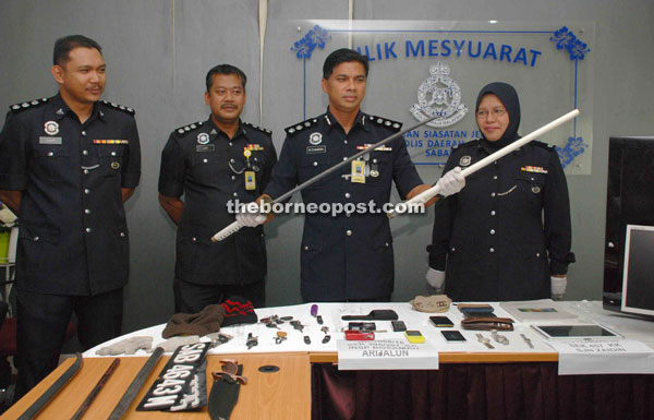 Chandra (second right) showing a samurai sword and other items that were seized from the suspects.