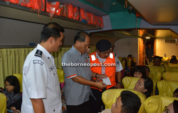 SRB Controller Jinep (centre) checking boat tickets. 