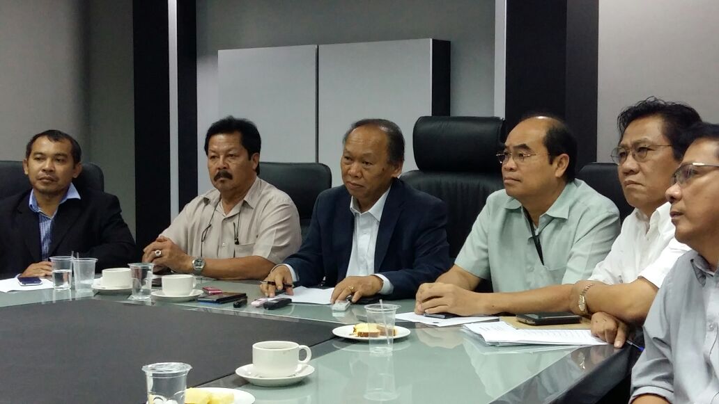 Nansian (centre) fielding questions from the press. Entri is seated to his left.