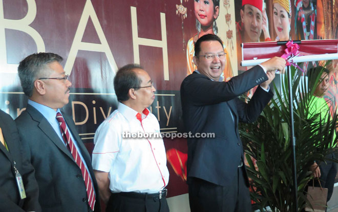 Pang (right) unveiling the Faces of Sabah artwork at KKIA which features the 34 races and faces of the people of Sabah. Next to him is Dr Wan Abdul Aziz.