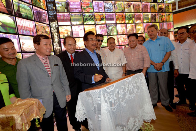 Musa signing the plaque to mark the opening of Sabah Forestry Department's Heart of Borneo @The Atrium exhibition hall yesterday. Looking on are Sam, Guntavid and James Wong.
