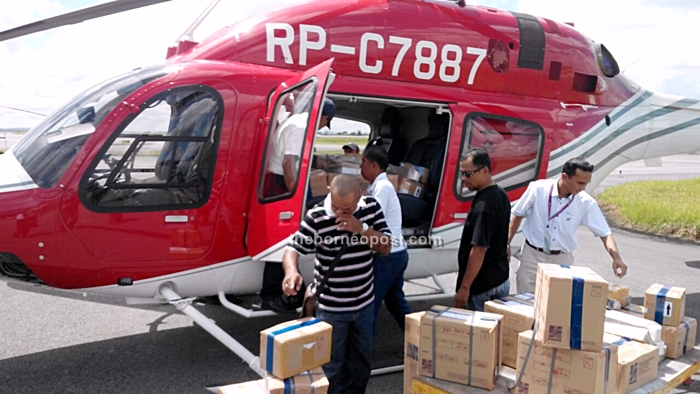 lection Commission staffs loading the ballot papers onboard one of the helicopters to be flown to their respective polling centres.