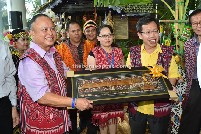 Chan (left) presents a souvenir to Dr Sim after the launch of the MBKS Pre-Gawai celebration. — Photo by Tan Song Wei