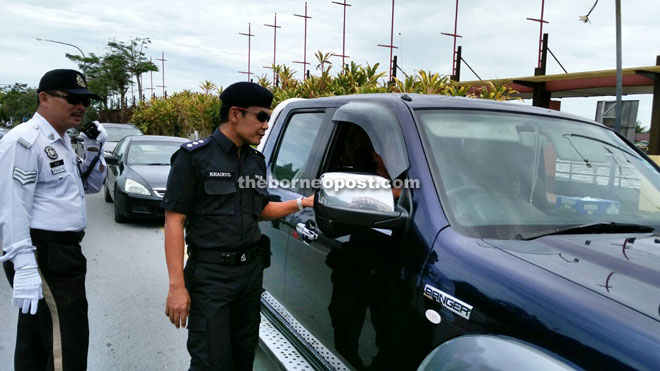 Khairul (second left) inspecting a Brunei registered vehicle during ‘operasi saman tertunggak warga asing (Brunei)’.