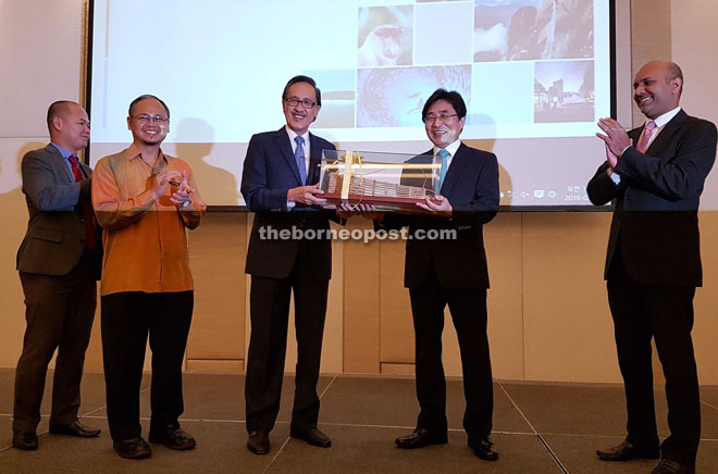 Masidi (centre) presenting a truly Sabah memento, Bubu (traditional fish trap), to Kim (second right) at the ASEAN-Korea Tourism Capacity Building Workshop in Kota Kinabalu yesterday.