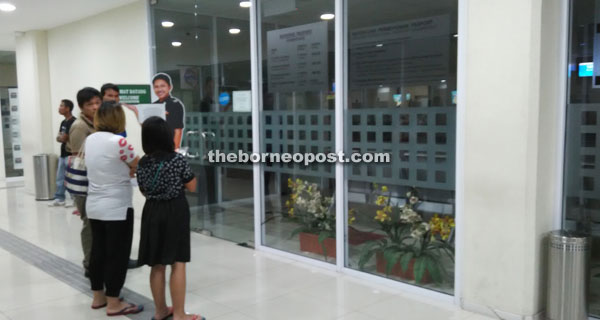 A family discussing what to do next after finding the Immigration Counter closed yesterday.