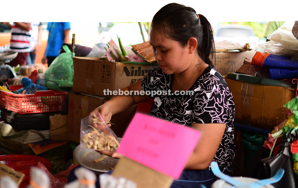 A trader weighs and packs the smoked fish for sale.