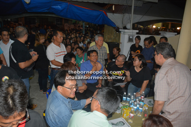 Dr Teo (seated, third right) shows those attending the wake some old bruises he sustained during an assault in front of his clinic at Jalan Permaisuri last year.