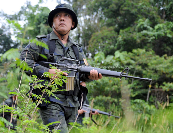 A General Operations Force (GOF) member from the 11th Battalion in Batu Kawah conducts a routine patrol along the checkpoint boundary in Telok Melano, Sematan which shares the border with West Kalimantan, Indonesia. — Bernama photo