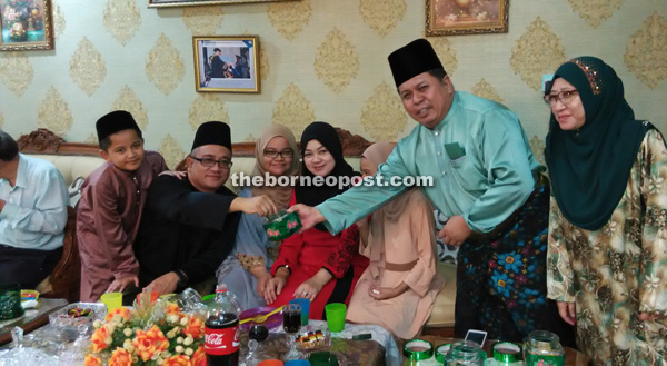 Ahmad (second right) and wife serving guests at his Raya open house.