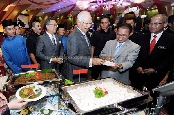 Najib serving Minister in the Prime Minister’s Department Datuk Joseph Entulu (second right) and during the Aidilfitri reception of the Prime Minister’s Department as others look on. — Bernama photo