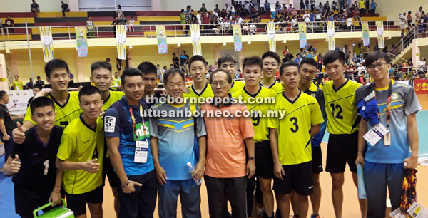 RAI KEMENANGAN: Liew (barisan depan, empat kiri) bersama pemain-pemainnya meraikan kemenangan ke atas Sarawak dalam acara bola tampar SUKMA XVIII di Sibu semalam.