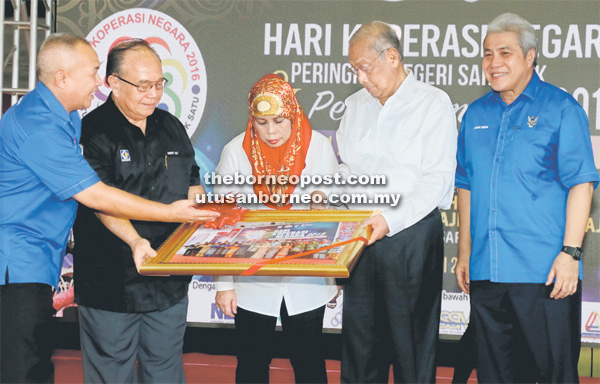 TEPA: Henry (dua kiba) nyuaka tepa ngagai Adenan, ti udah bejadi Hari Koperasi Negara Peringkat Nengeri Sarawak, seraya dikemataka Awang Tengah ((kanan).