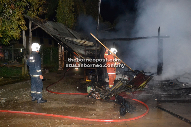 The Fire and Rescue Department personnel putting out the house fire in Kampung Damai.