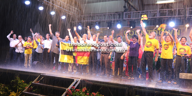 Yii (eighth from right), with Ting on his left, joins others on stage to shout ‘Happy Sarawak Day’ amidst heavy rain.