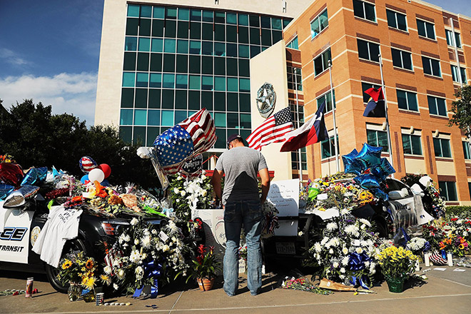 People write condolence notes and lay flowers at a growing memorial in front of the Dallas Police Headquarters near the area that is still an active crime scene following the deaths of five police officers. — AFP photo