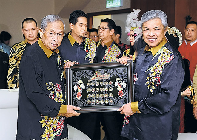 CENDERAMATA: Timbalan Perdana Menteri Datuk Seri Dr Ahmad Zahid Hamidi menerima cenderamata daripada Ketua Menteri Datuk Patinggi Tan Sri Adenan Satem (kiri) pada majlis penutupan SUKMA ke-18 di Stadium Sarawak. Turut hadir Menteri Belia dan Sukan, Khairy Jamaluddin (tiga kiri) malam tadi. — Gambar Bernama