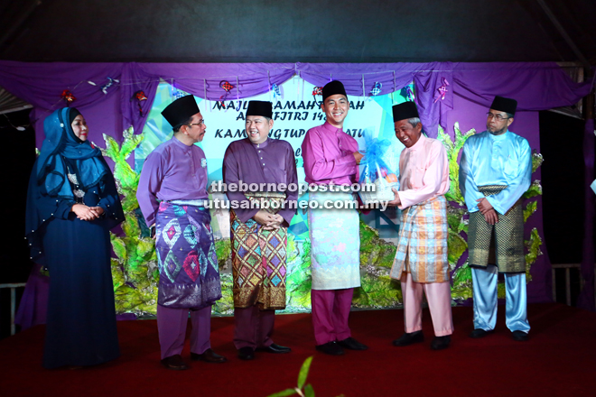 Fazzruddin (third right) receives a memento from a representative of Kampung Tupong Batu JKKK.