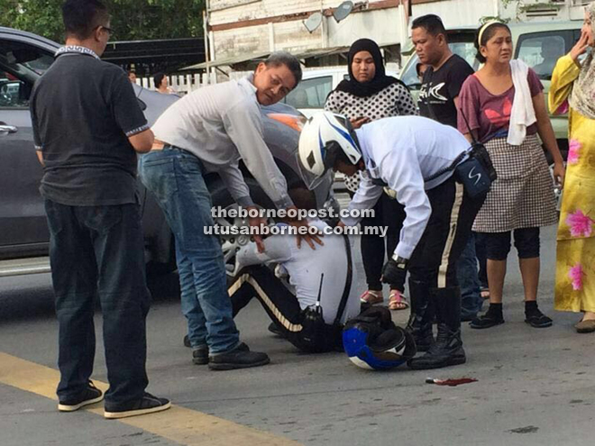 The injured policeman being attended to by his colleagues and members of the public.