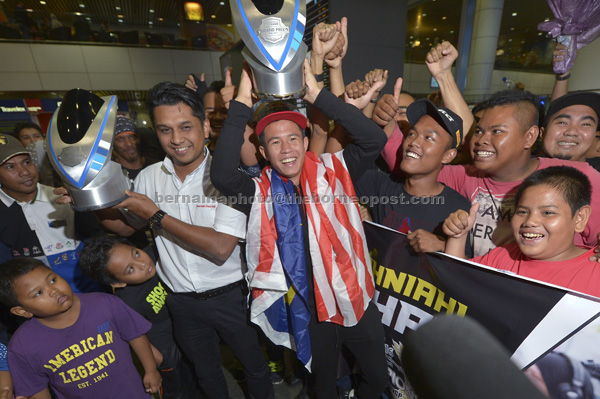 BANGGA: Khairul menjulang piala kemenangan sejurus tiba di Lapangan Terbang Antarabangsa Kuala Lumpur (KLIA) dalam gambar fail bertarikh 22 Julai 2016. — Gambar Bernama