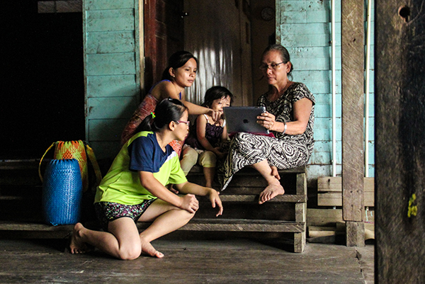 Villagers look at an iPad in Long Luyang.