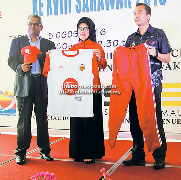 PAKAIAN RASMI: Fatimah dan Subramaniam (kiri) memperagakan pakaian rasmi Sukan Paralimpiad Ke-18 tajaan syarikat Tune Talk.