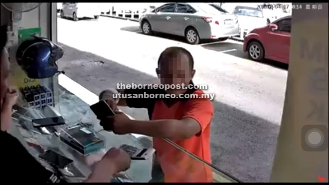 KANTOI: Gambar skrin rakaman CCTV menunjukkan suspek memegang telefon bimbit di kedai berkenaan sebelum melarikan diri. 