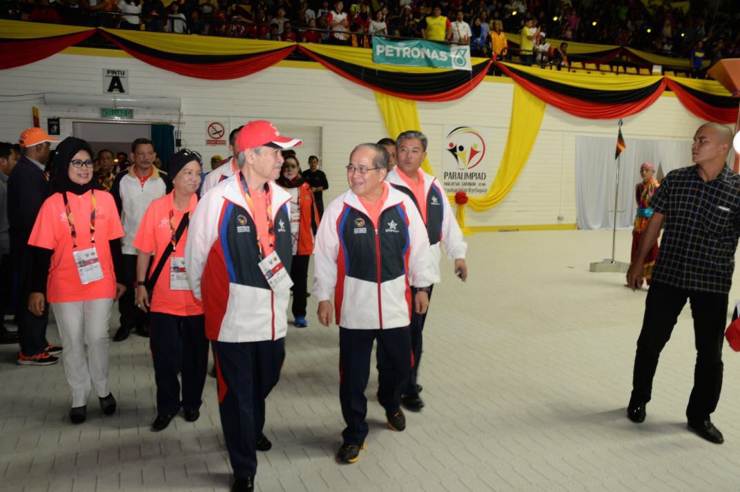 Uggah (second right) talking to former prime minister Abdullah as they arrive at the stadium. 