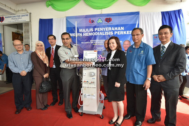 Azman (fourth left) hands over a haemodialysis machine to Lay Ping. Kwang Khim is at third left. 